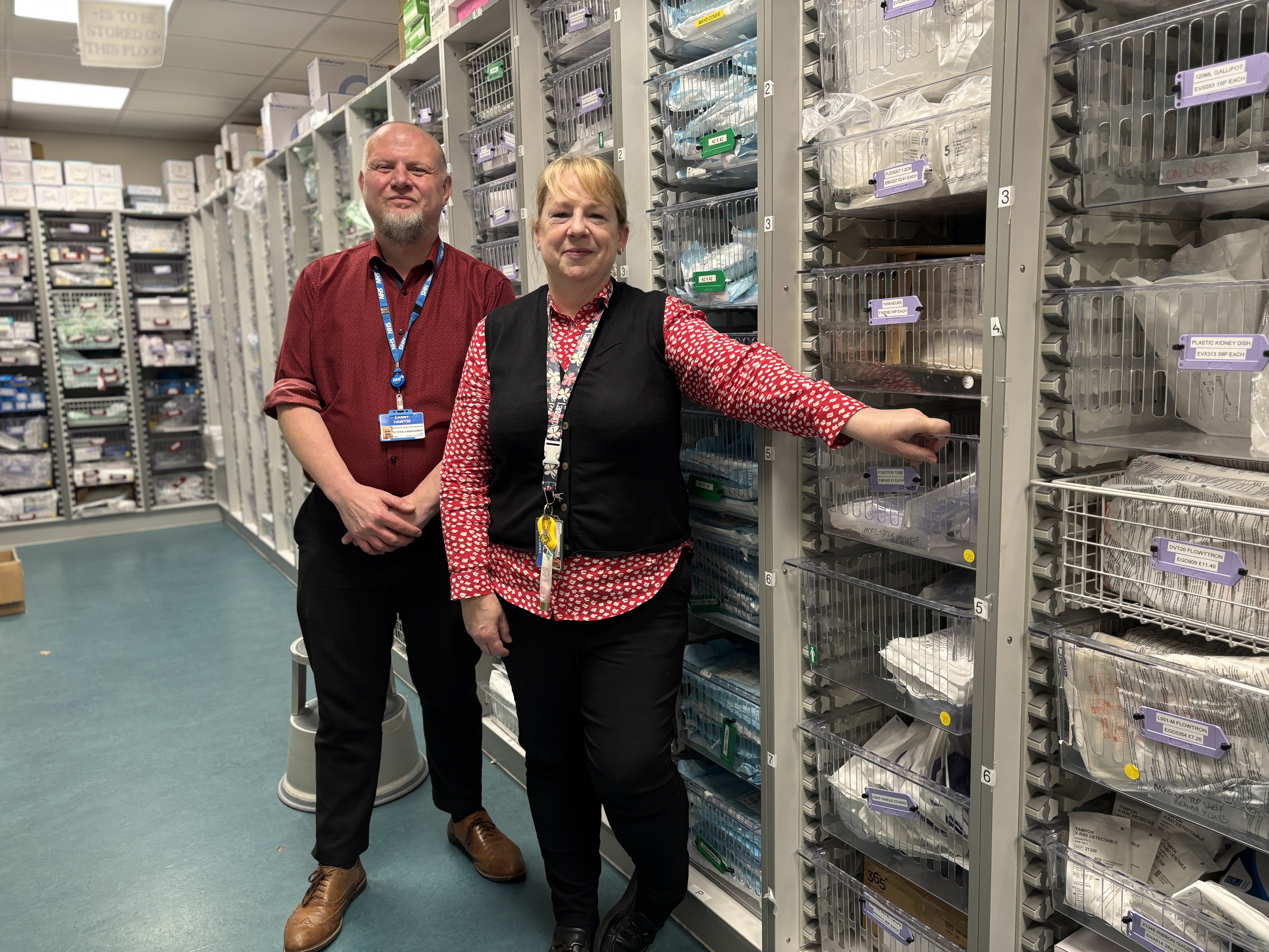 Man and woman stood in front of drawers containing medical resources 