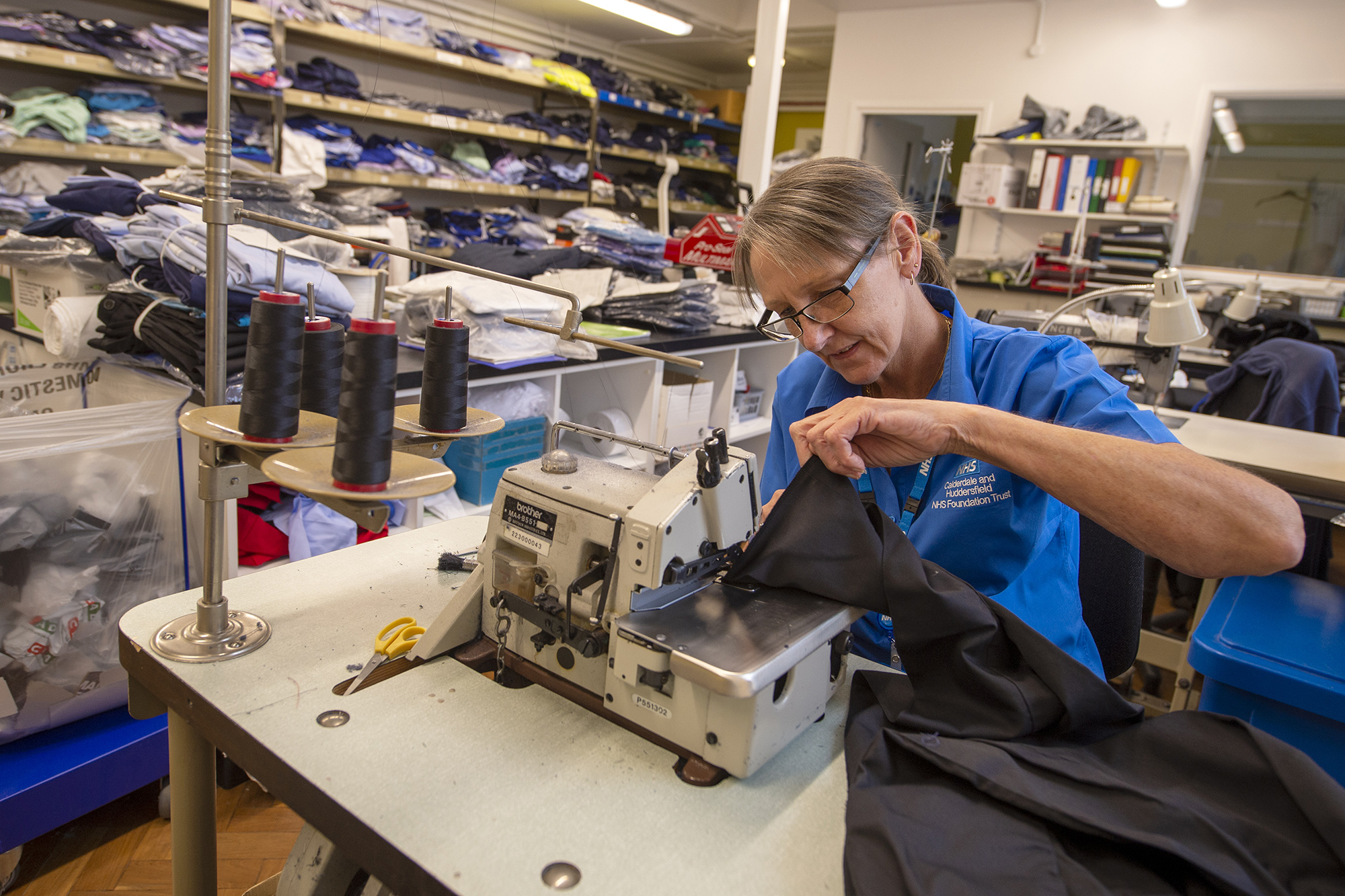 Female staff member sowing clothes.