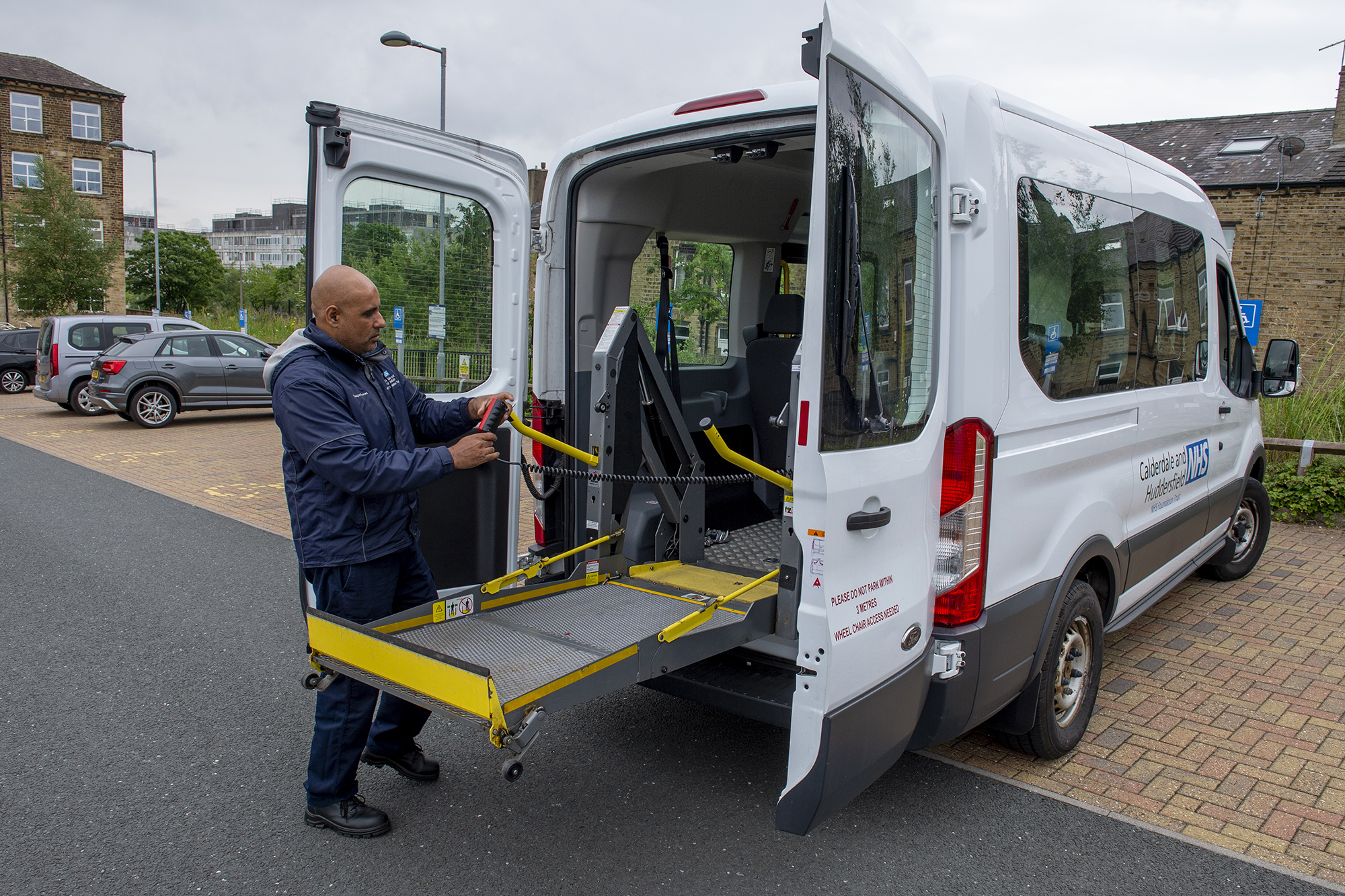 Male member of staff operating the lift in the shuttle bus.
