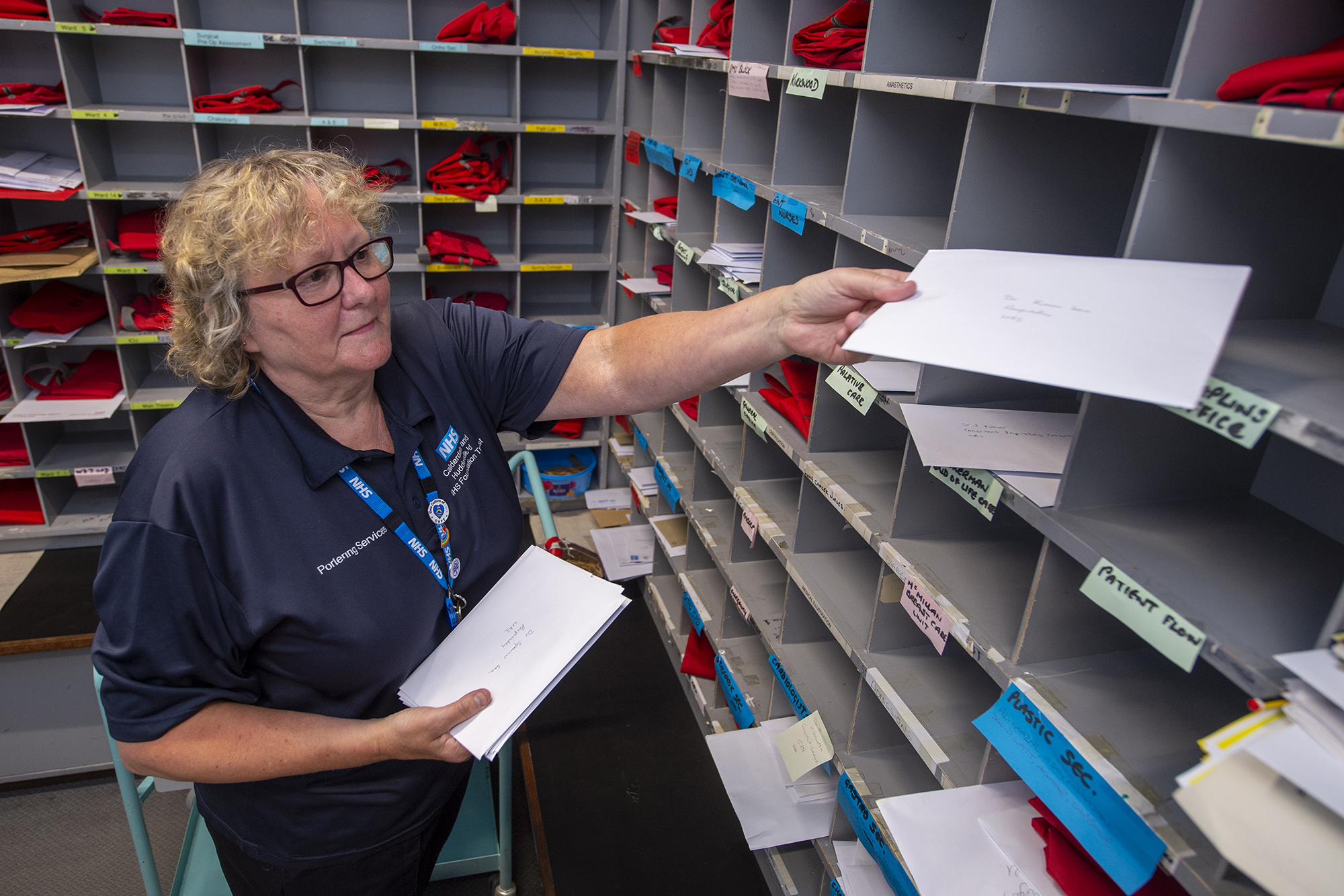 Female member of staff putting letter into pigeon holes.