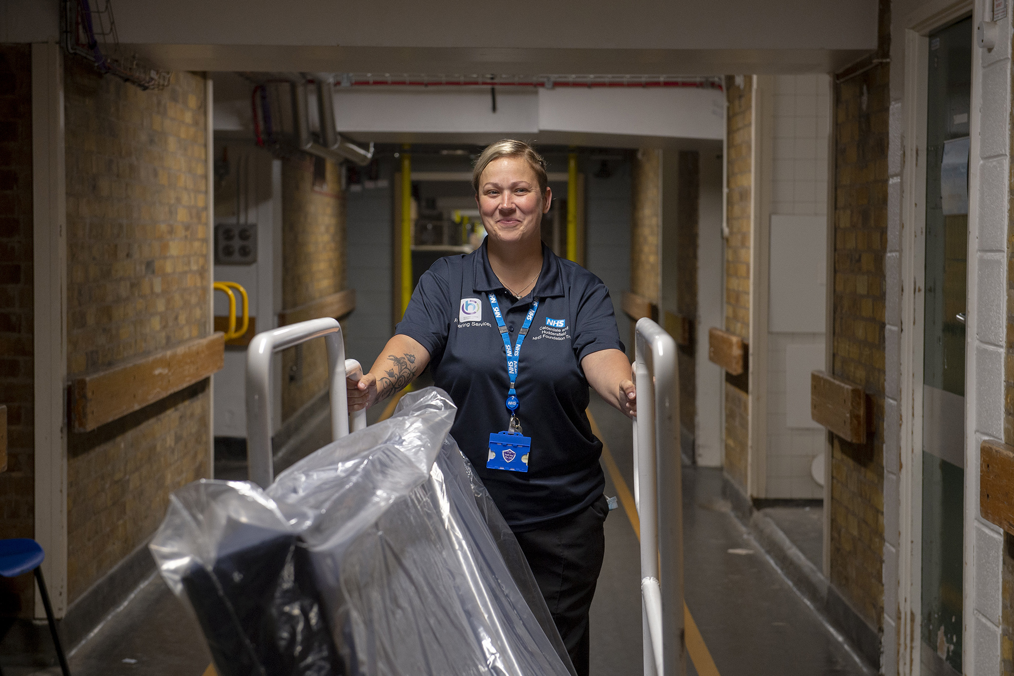 Female employee pushing a trolly down a corridor. 